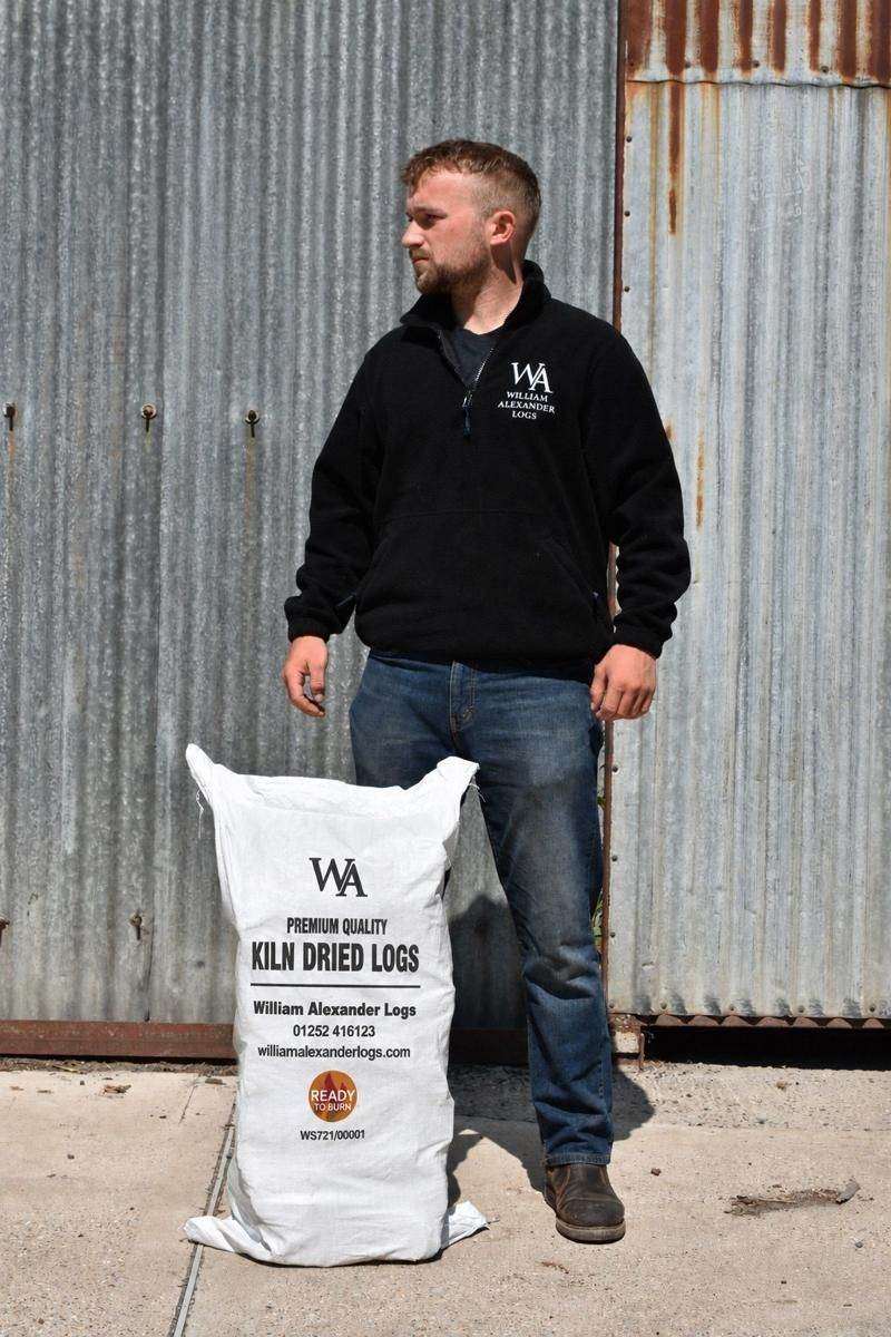 A member of the William Alexander team with a bag of logs